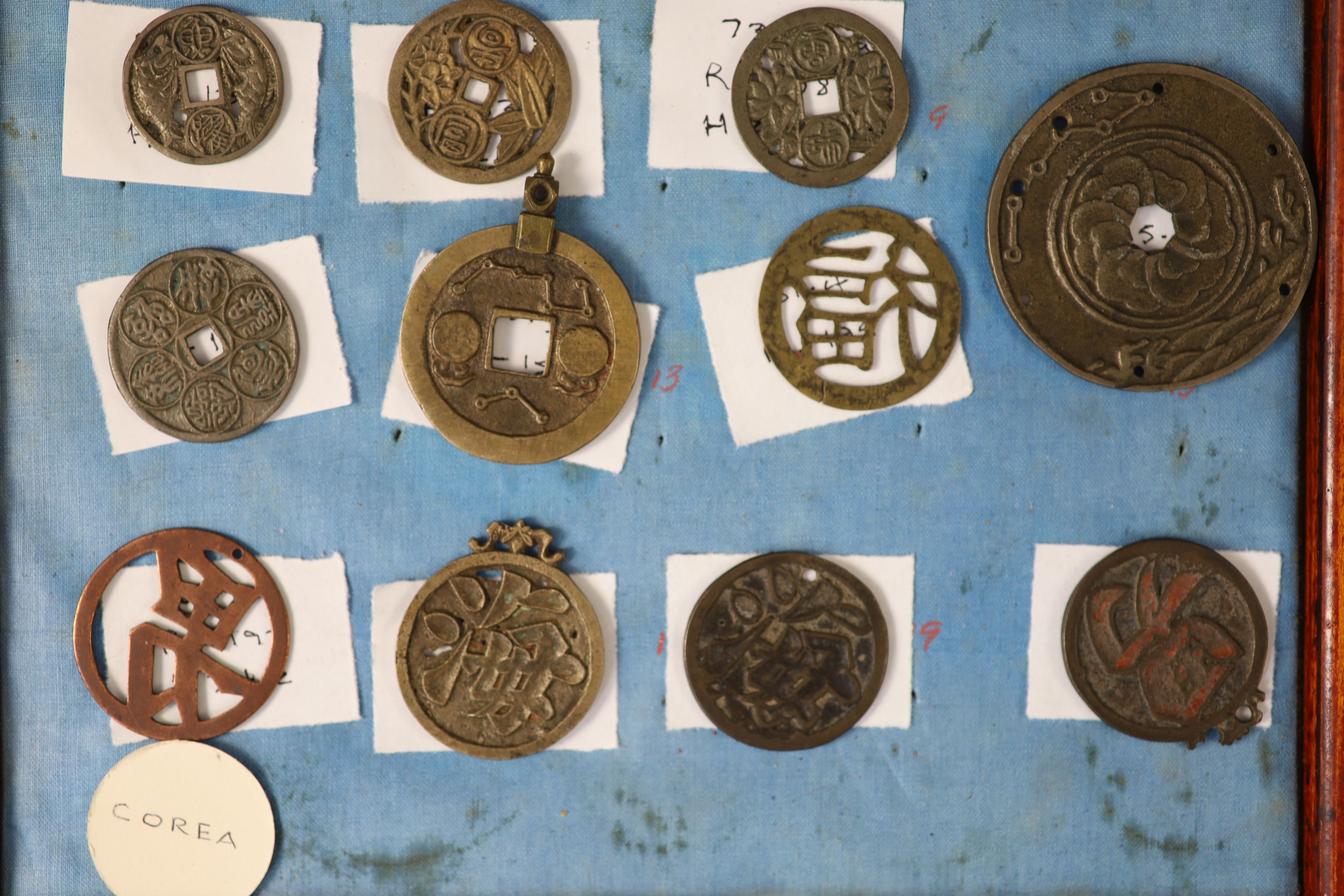 A group of 99 Korean bronze and metal amulets or charms, 19th/20th century